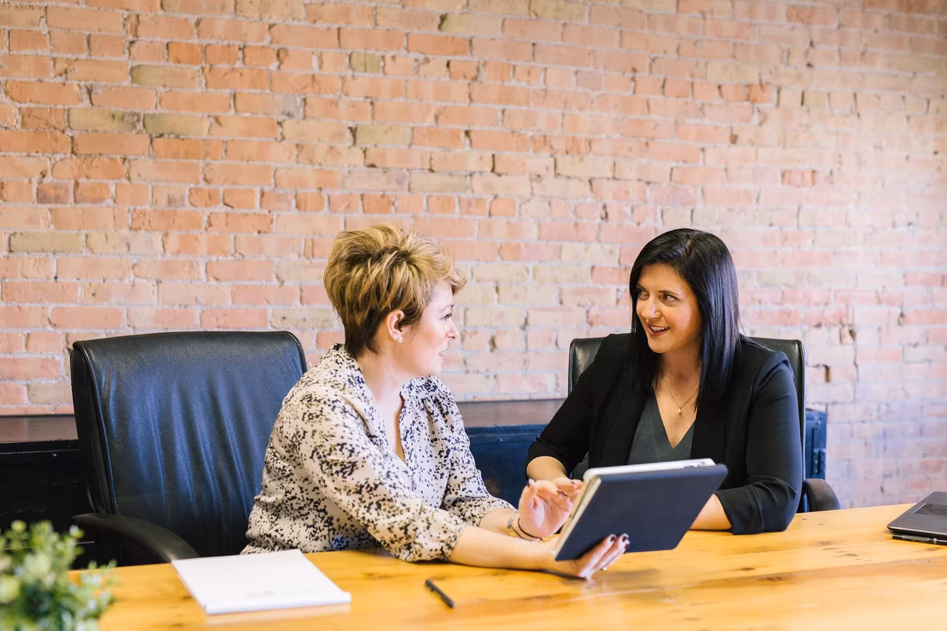 2 women have a meeting at a table and having a discussion