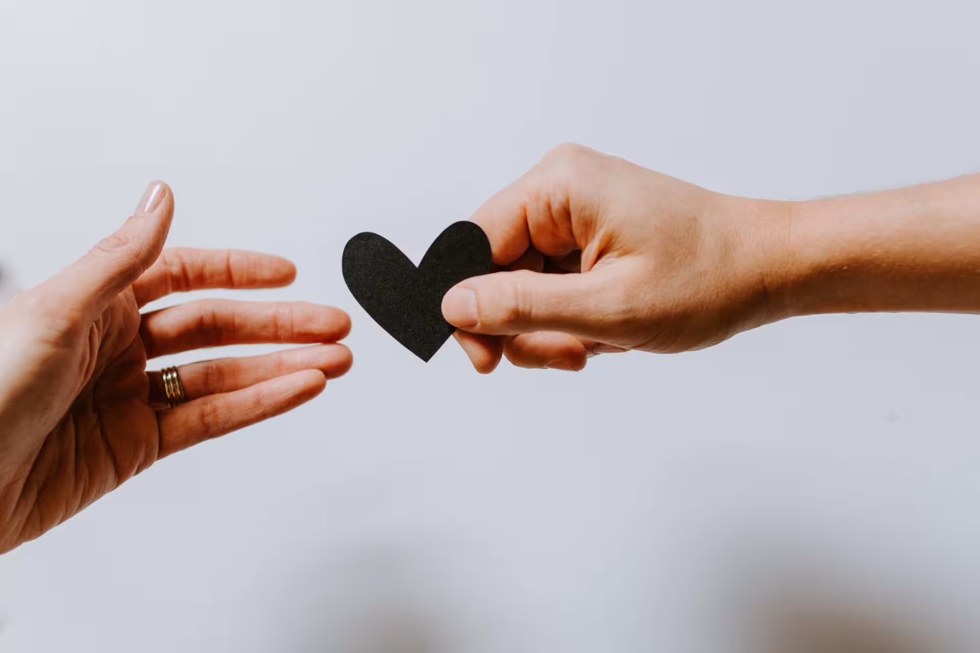 Person handing over a black heart print